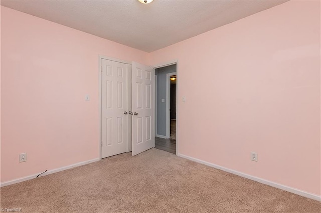 unfurnished room with carpet floors and baseboards