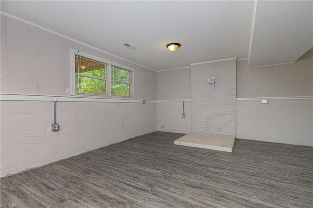 unfurnished room with ornamental molding, visible vents, and wood finished floors