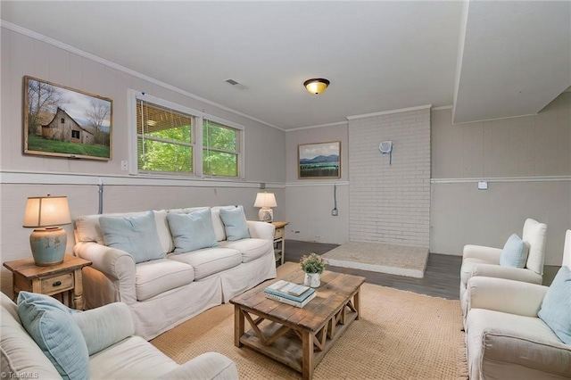 living area with crown molding, visible vents, and wood finished floors