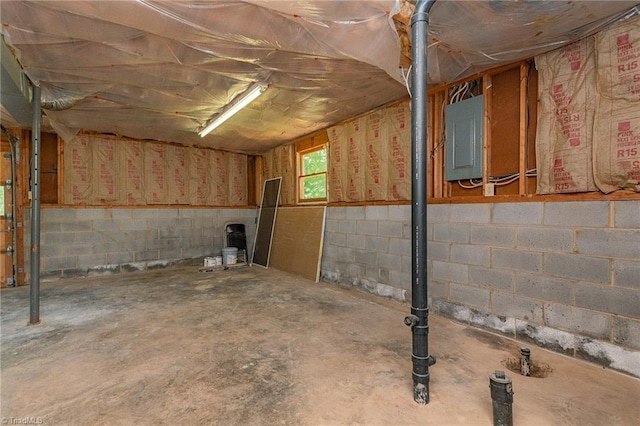 basement with electric panel and concrete block wall