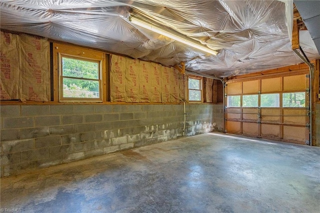 below grade area featuring a garage and concrete block wall