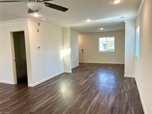 spare room featuring crown molding, baseboards, and dark wood-type flooring