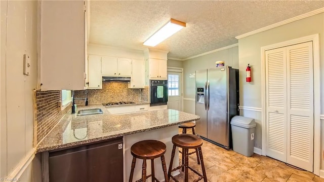 368 Shady Grove Rd, Eden, NC 27288 - kitchen with stainless steel refrigerator with ice dispenser, black oven, under cabinet range hood, a textured ceiling, and tasteful backsplash