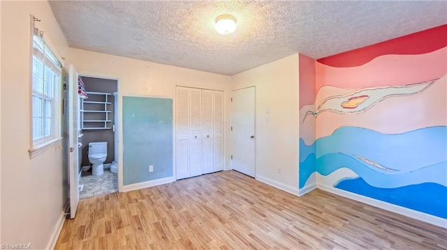 368 Shady Grove Rd, Eden, NC 27288 - unfurnished bedroom featuring wood finished floors, a textured ceiling, a closet, and ensuite bathroom