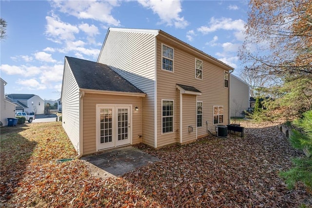 rear view of house with central AC unit, a patio, and french doors