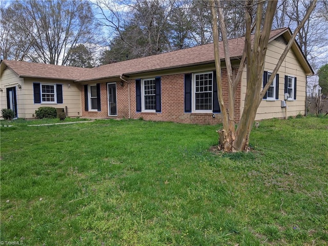 ranch-style house with roof with shingles, a front lawn, and brick siding