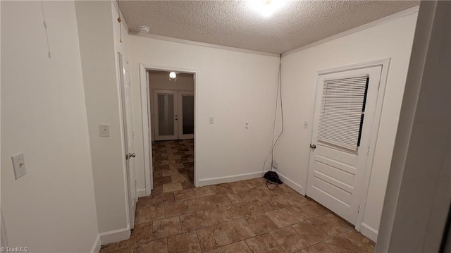 clothes washing area with a textured ceiling and baseboards