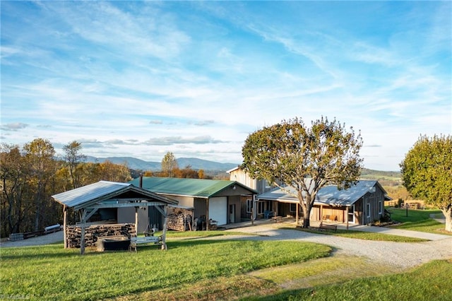 ranch-style home with a front yard, a garage, and a mountain view