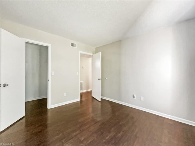 unfurnished bedroom with dark hardwood / wood-style flooring, a textured ceiling, and a closet