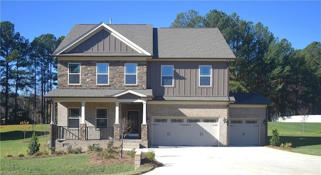 craftsman house with concrete driveway, board and batten siding, a porch, and a front yard