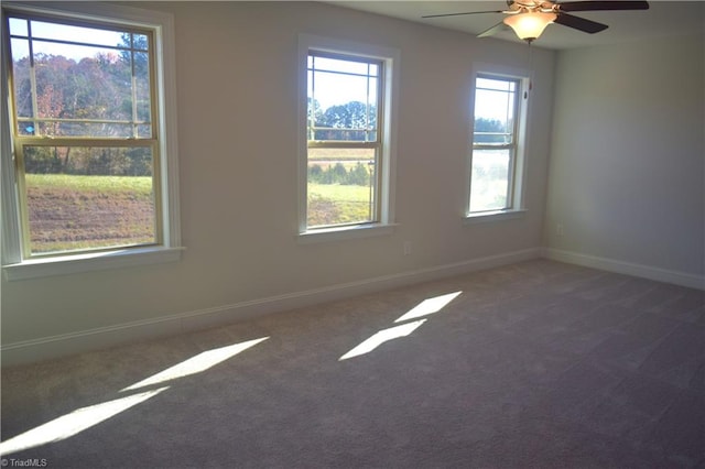 carpeted empty room with a wealth of natural light and ceiling fan