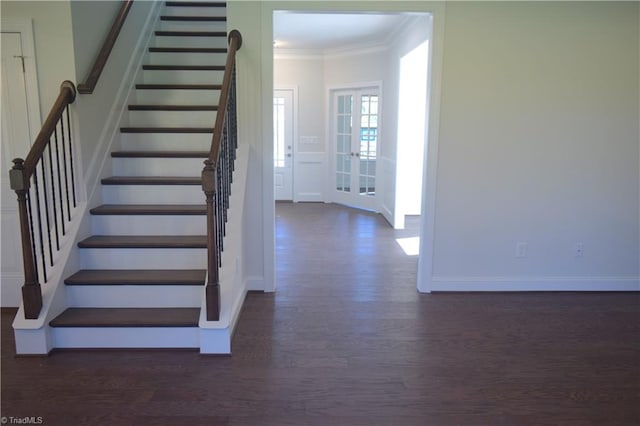 staircase with wood-type flooring, ornamental molding, and french doors