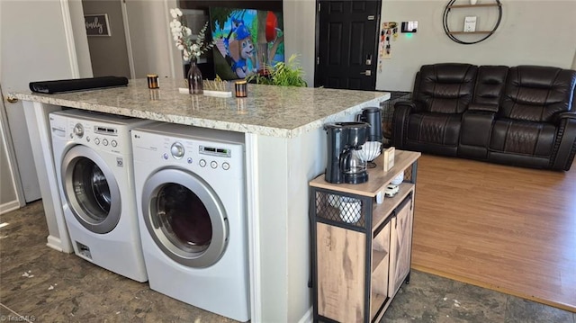 washroom with laundry area, washing machine and clothes dryer, and dark wood finished floors