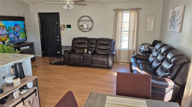 living area with light wood-type flooring and ceiling fan