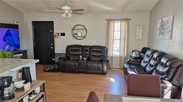 living room featuring light wood-type flooring and ceiling fan