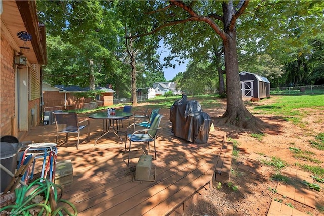 214 Stokes Forest Dr, King, NC 27021 - wooden terrace with outdoor dining area, a storage unit, a fenced backyard, and view of wooded area