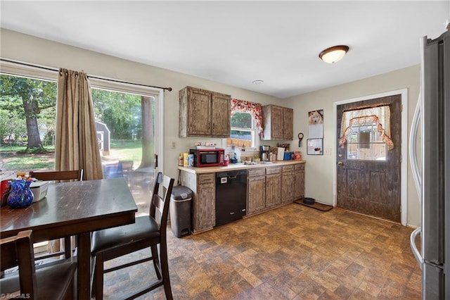 214 Stokes Forest Dr, King, NC 27021 - kitchen featuring stainless steel appliances, light countertops, brown cabinetry, and stone finish floors