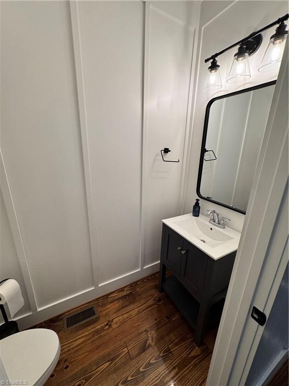3064 Wesley Farm Ln, Sophia, NC 27350 - half bath featuring wood finished floors, vanity, and toilet