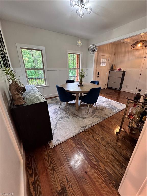 3064 Wesley Farm Ln, Sophia, NC 27350 - dining space with wood finished floors, a wainscoted wall, and a chandelier