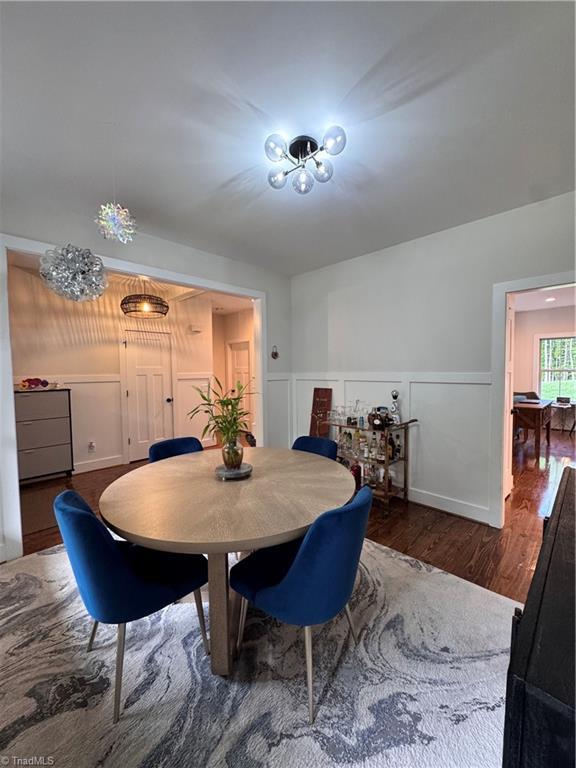 3064 Wesley Farm Ln, Sophia, NC 27350 - dining area with wood finished floors, a wainscoted wall, and a decorative wall