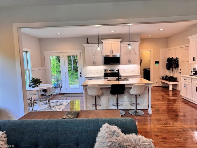 3064 Wesley Farm Ln, Sophia, NC 27350 - kitchen with appliances with stainless steel finishes, dark wood finished floors, white cabinetry, a breakfast bar area, and backsplash