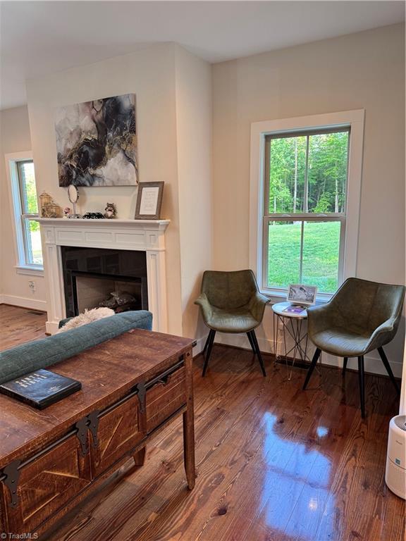 3064 Wesley Farm Ln, Sophia, NC 27350 - living area featuring wood finished floors, a fireplace, and baseboards