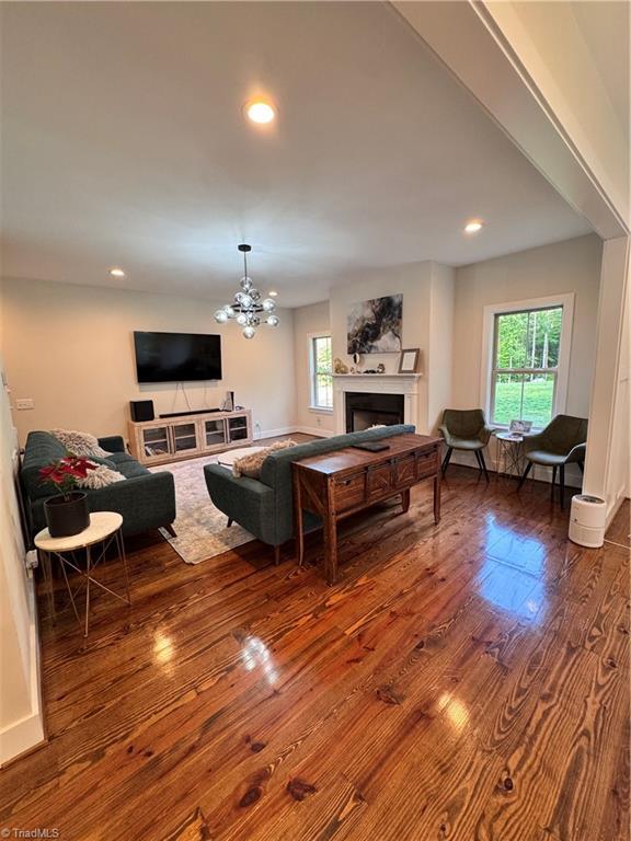 3064 Wesley Farm Ln, Sophia, NC 27350 - living area with wood finished floors, a fireplace, recessed lighting, and a chandelier