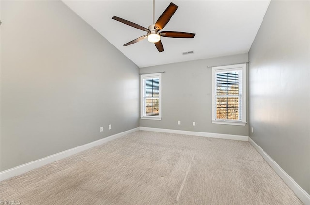 spare room with light colored carpet, ceiling fan, vaulted ceiling, and a wealth of natural light