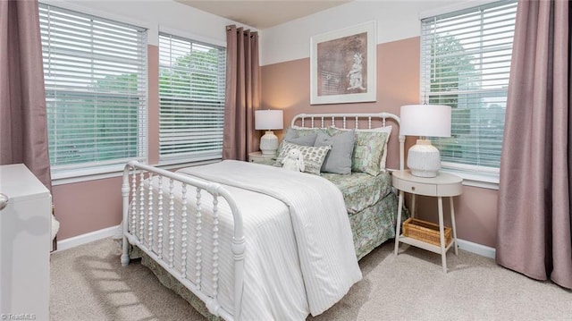 bedroom with light colored carpet and multiple windows