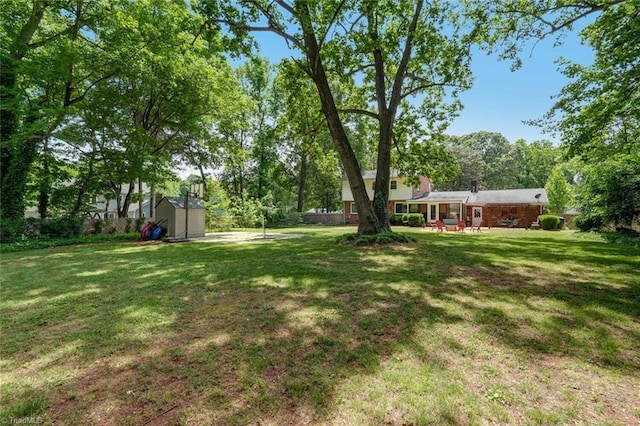 1274 Candlewood Dr, Elon, NC 27244 - view of grassy yard with a storage shed, an outdoor structure, and a patio area
