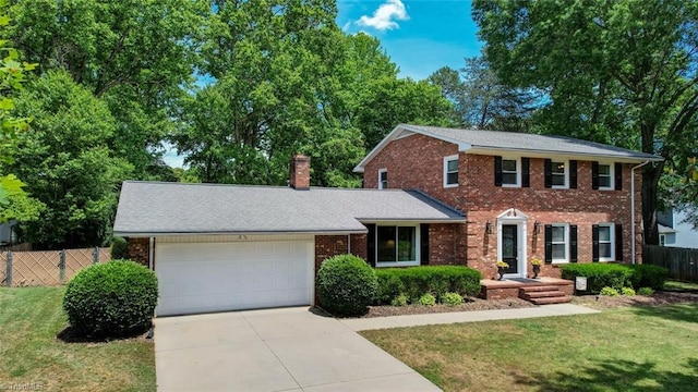 1274 Candlewood Dr, Elon, NC 27244 - colonial-style house with a garage, driveway, brick siding, and a chimney