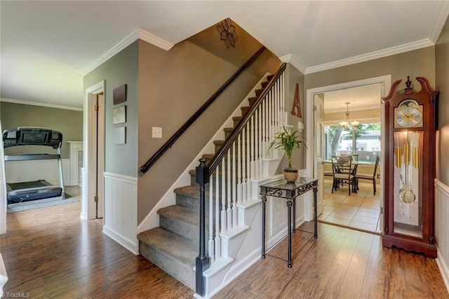 1274 Candlewood Dr, Elon, NC 27244 - stairs featuring wood finished floors, a chandelier, crown molding, and a wainscoted wall