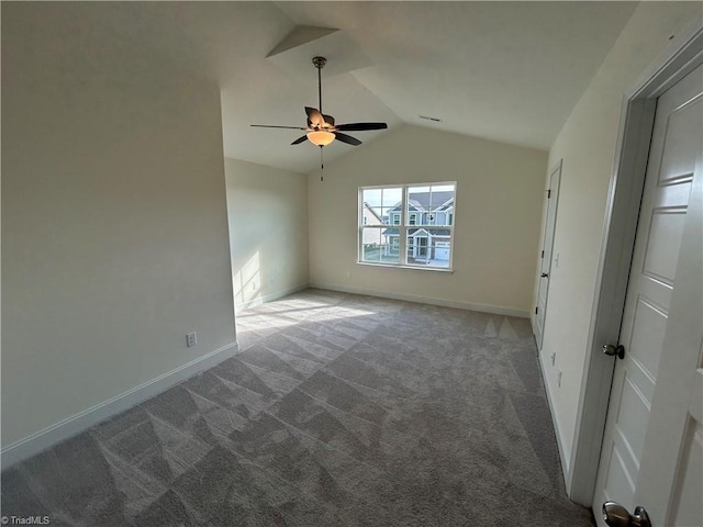 empty room featuring vaulted ceiling, ceiling fan, and carpet