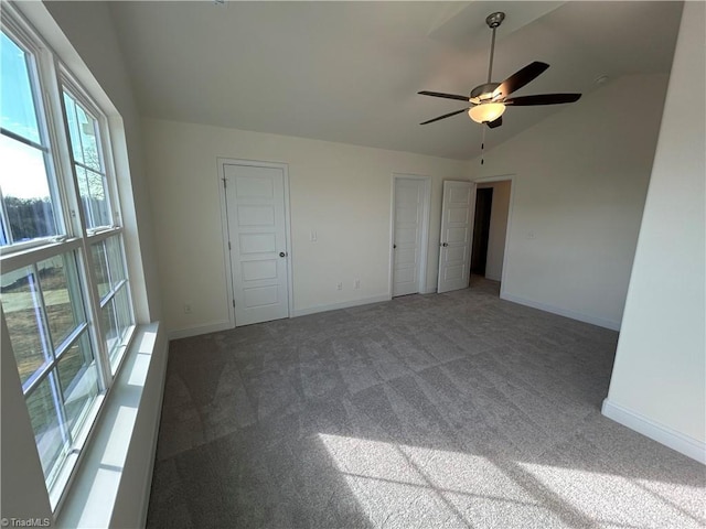 carpeted empty room featuring ceiling fan and lofted ceiling