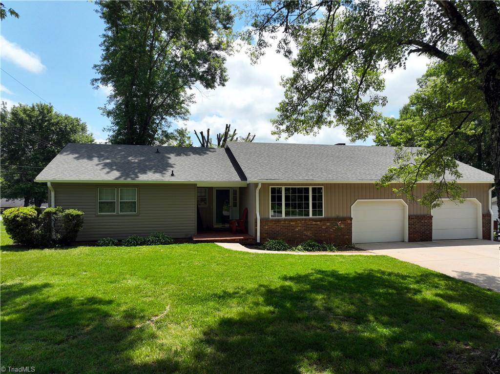 321 Shoals Rd, Pinnacle, NC 27043 - ranch-style house featuring brick siding, a garage, concrete driveway, and a front yard