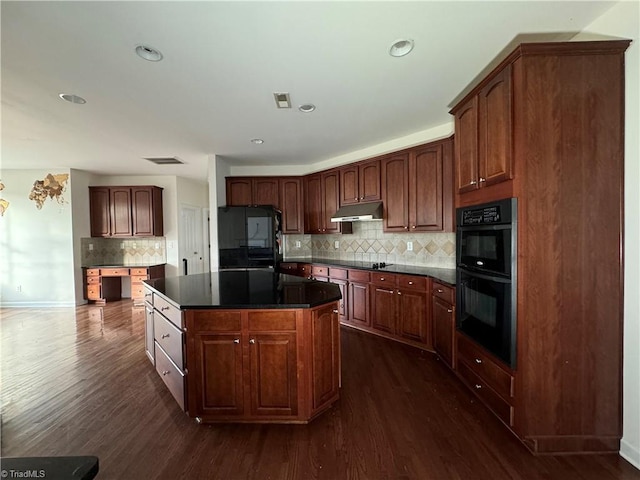 kitchen with black appliances, dark hardwood / wood-style floors, a kitchen island, and backsplash