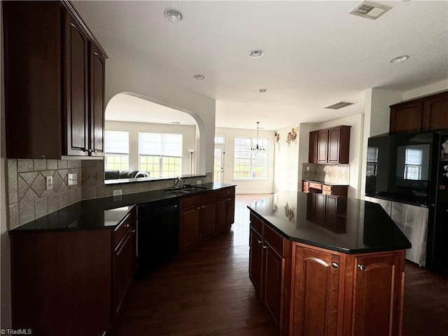 kitchen with sink, dark hardwood / wood-style floors, black dishwasher, tasteful backsplash, and a kitchen island