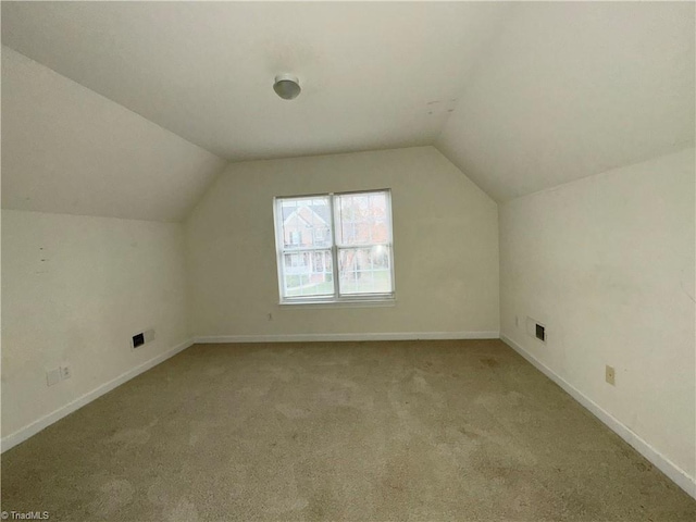 additional living space featuring lofted ceiling and light carpet