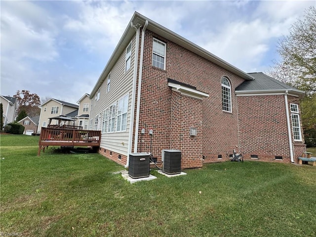 back of property with a yard, a wooden deck, and central AC