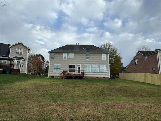 rear view of house with a lawn and a wooden deck