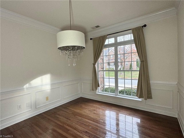 unfurnished room featuring a notable chandelier, a healthy amount of sunlight, and dark hardwood / wood-style flooring