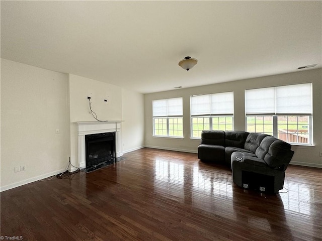 living room featuring a wealth of natural light and dark wood-type flooring