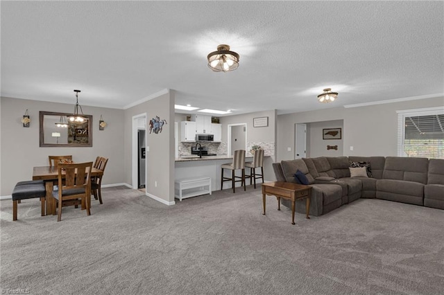 carpeted living room featuring a notable chandelier, ornamental molding, and a textured ceiling