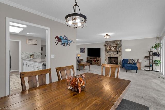 carpeted dining room featuring crown molding and a fireplace