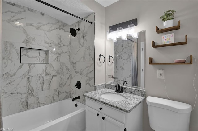 full bathroom with vanity, tiled shower / bath, and toilet