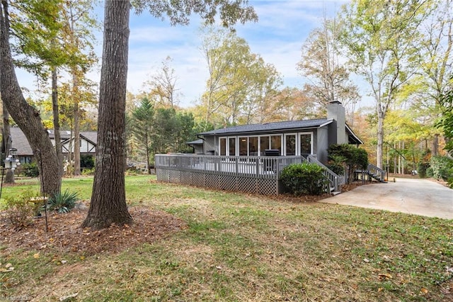 back of house featuring a wooden deck and a yard