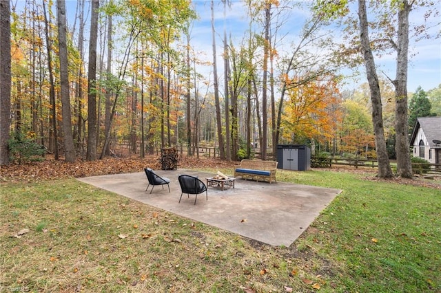 view of yard with a shed, a patio area, and an outdoor fire pit