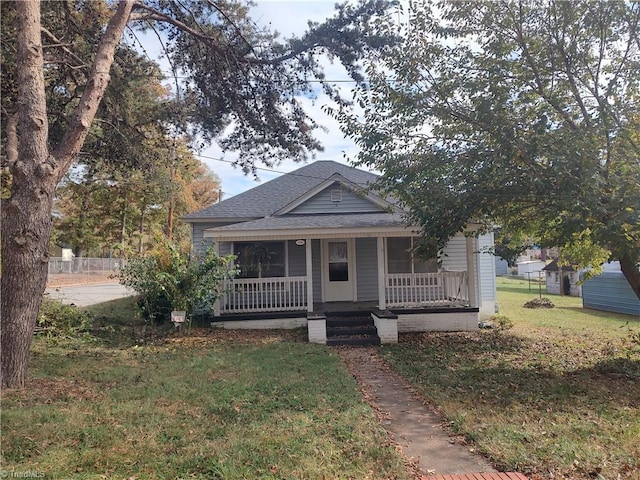 bungalow featuring covered porch and a front yard