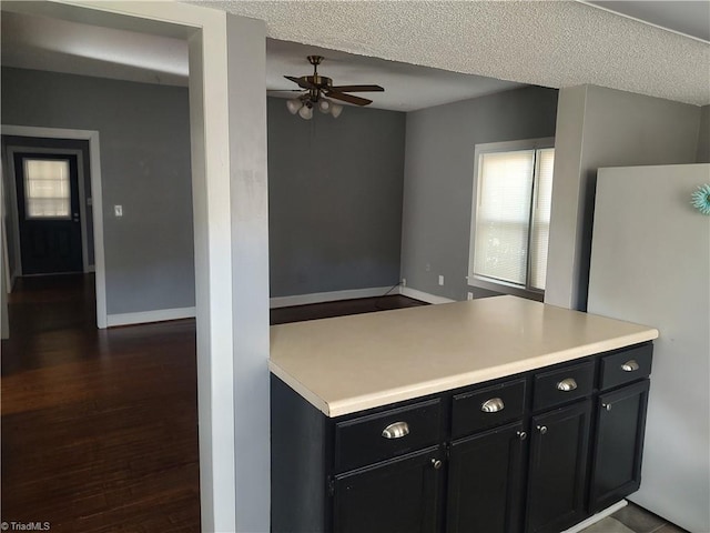 kitchen featuring ceiling fan, dark hardwood / wood-style floors, a textured ceiling, and white fridge