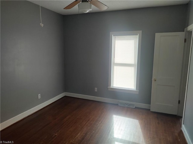 spare room featuring dark wood-type flooring and ceiling fan